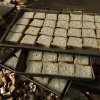Workers arrange the cut bread in the trays